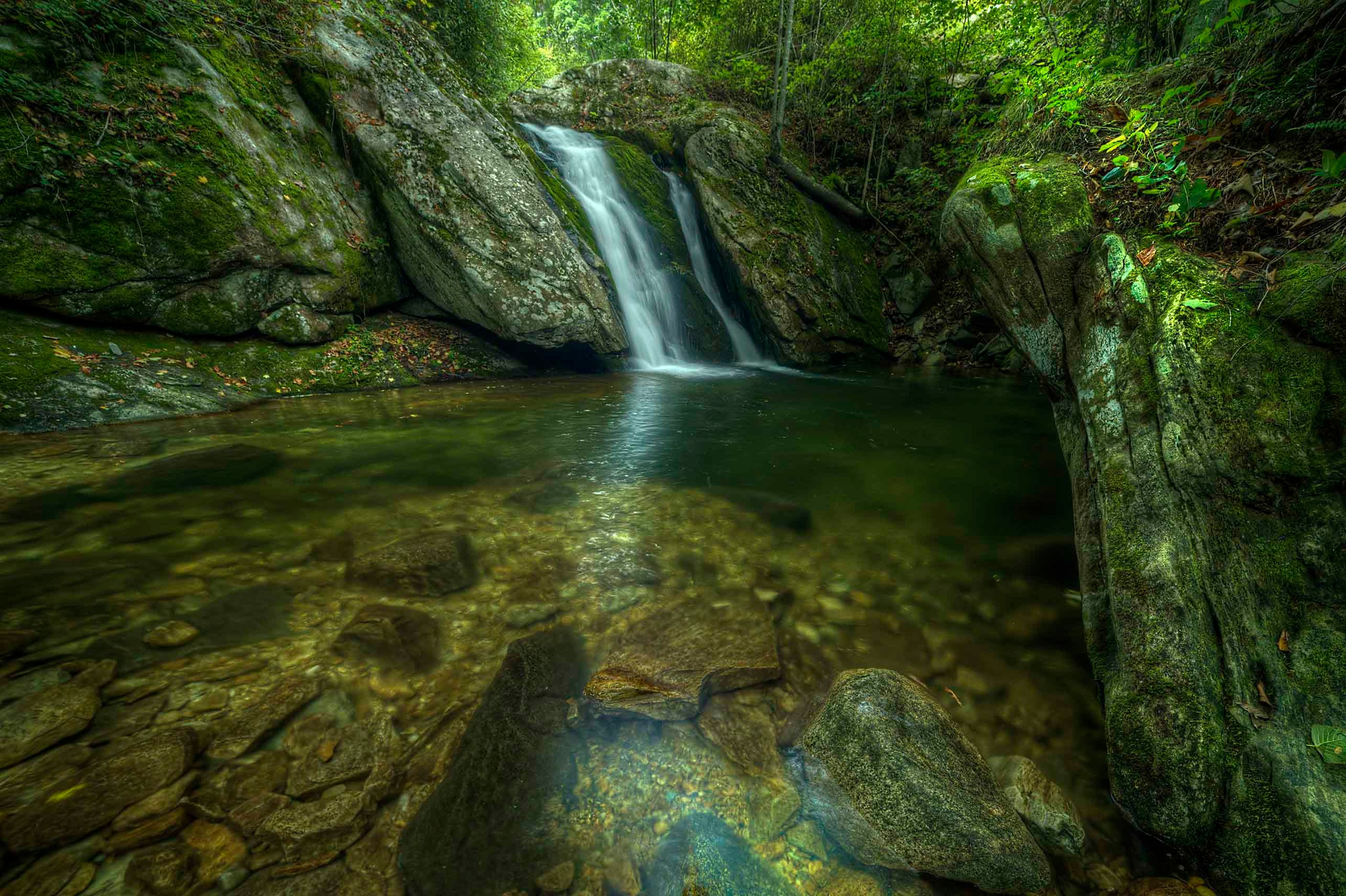 Big Creek Falls NC cascading into a clear emerald pool surrounded by moss-covered boulders